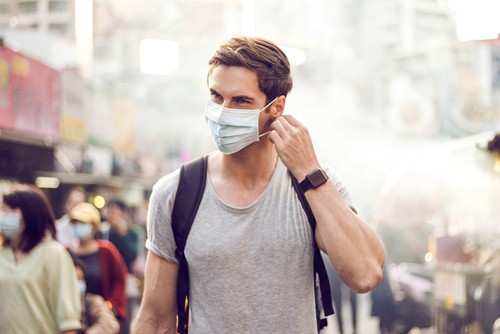young man wearing mask in marketplace